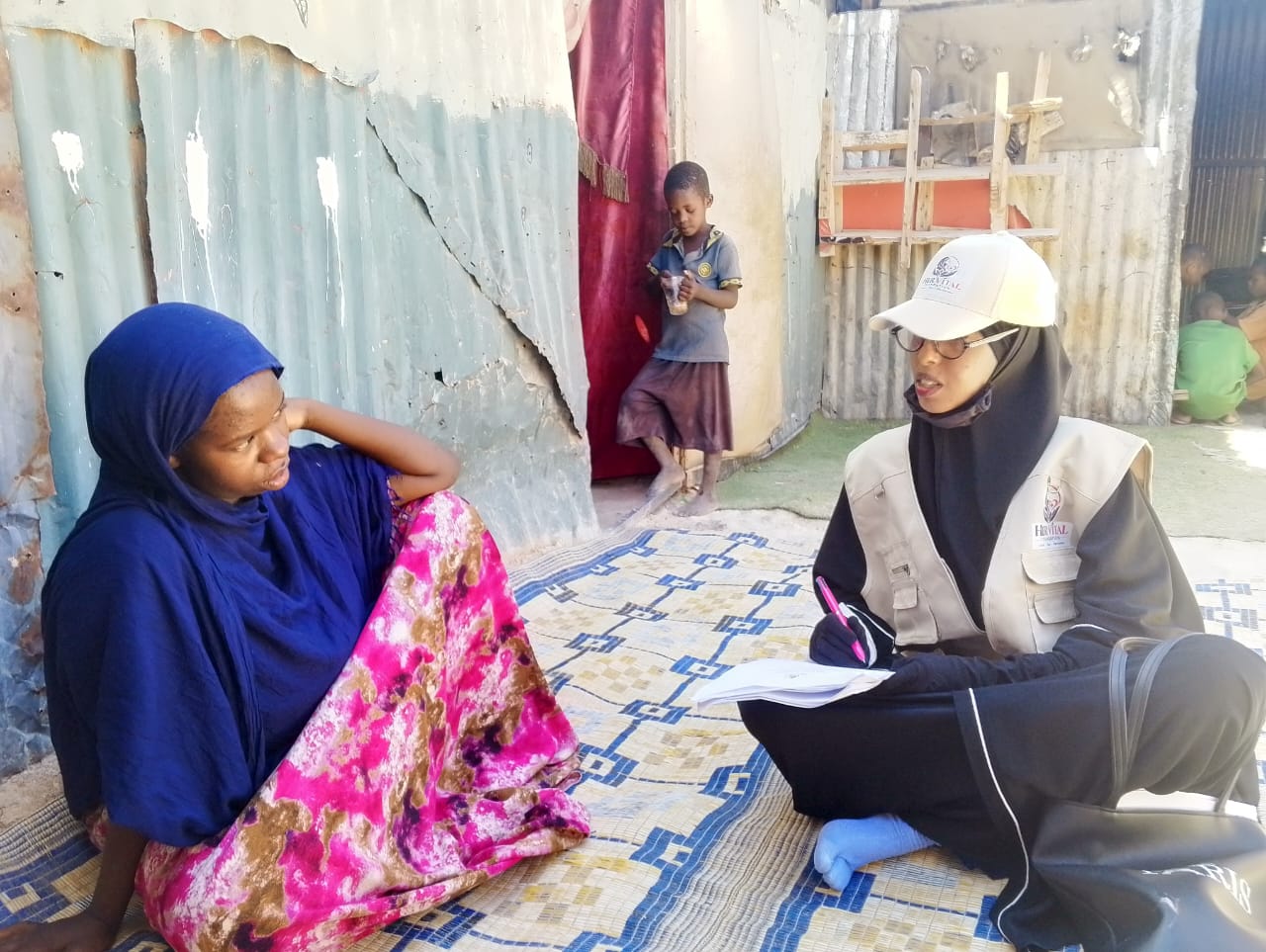 Her Vital Foundation staff member speaking with a community member during a field visit